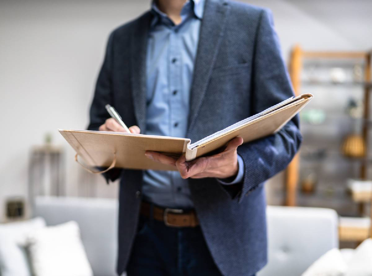 cropped image of person in a suit writing notes in a folder