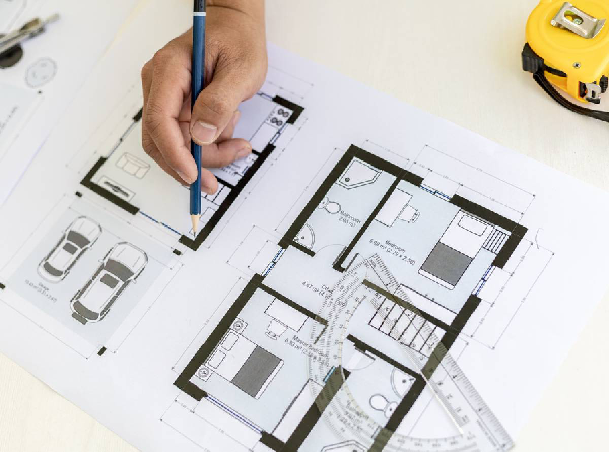 close up of hand and pencil drawing on a plan of a property