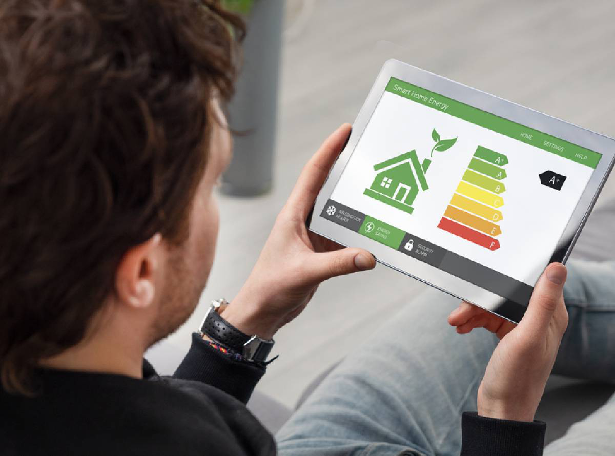 Overhead view of a man holding a tablet with screen showing an energy efficiency chart
